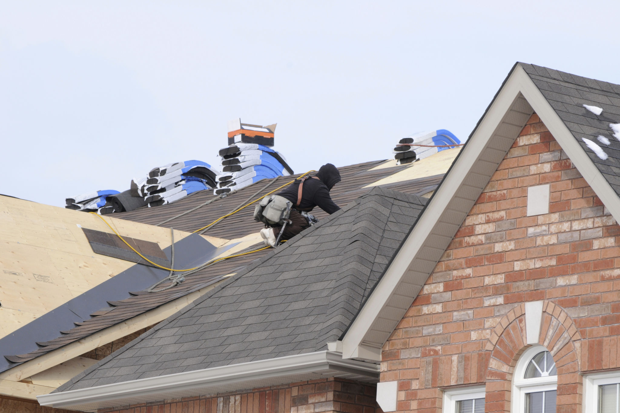 Roofer installing new asphalt shingles